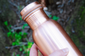 holding smooth copper bottle zoomed